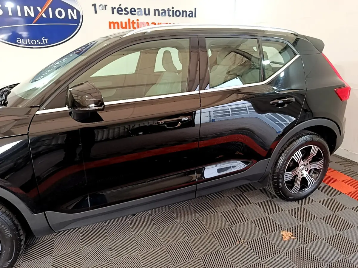 Profil côté gauche du Volvo XC40 T3 noir 2020 avec jantes alliage et vitres teintées en intérieur showroom.