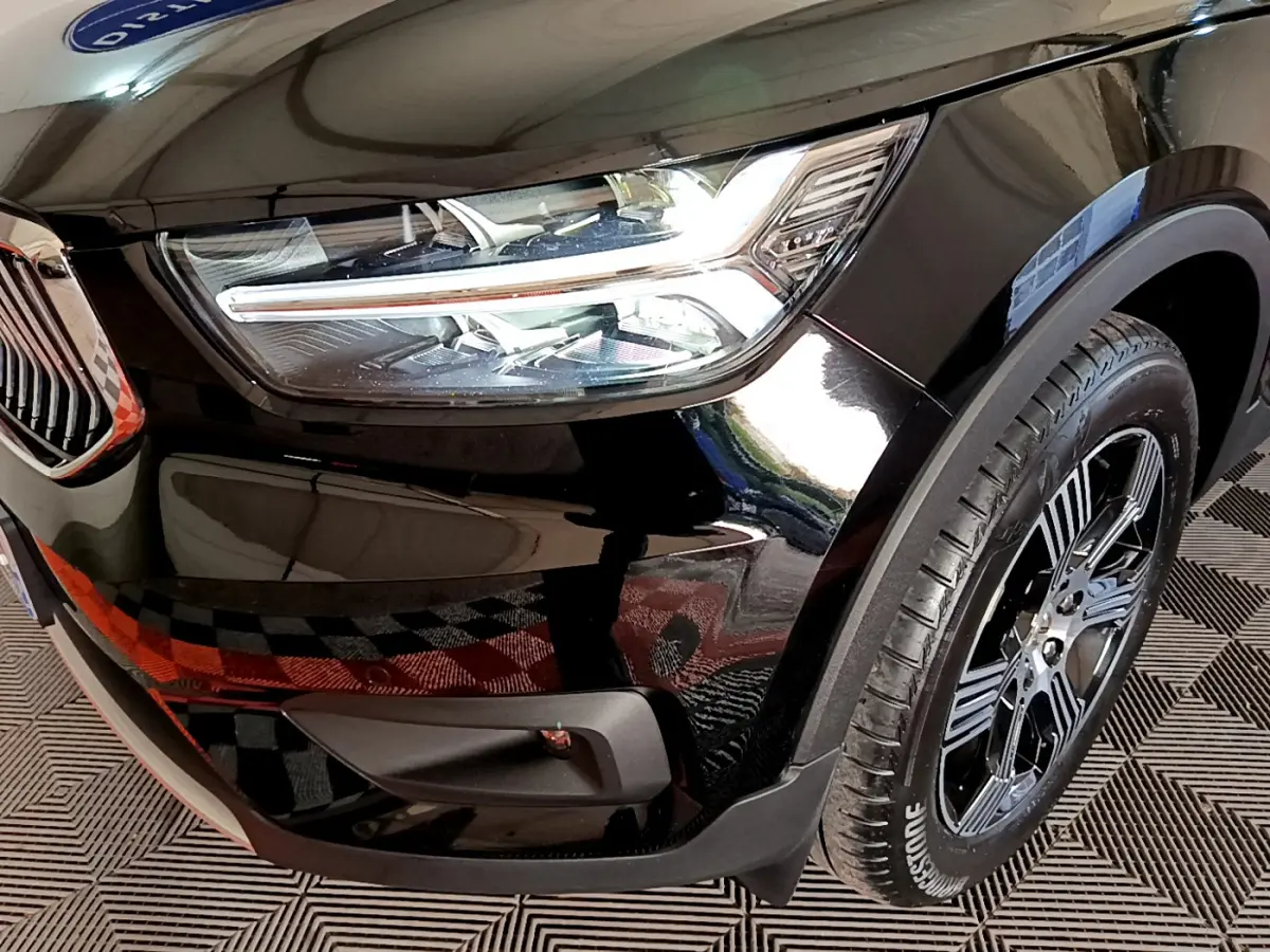 Gros plan sur l'avant droit noir du Volvo XC40 T3 2020, mettant en valeur le phare LED et la roue à jante noire.