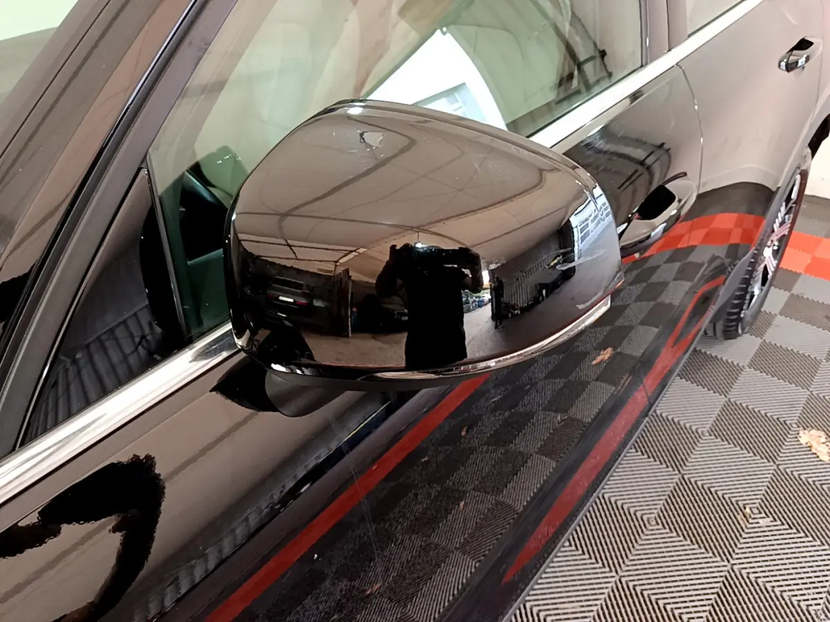 Rétroviseur côté gauche noir brillant du Volvo XC40 T3 2020, avec reflet d'intérieur de garage visible.