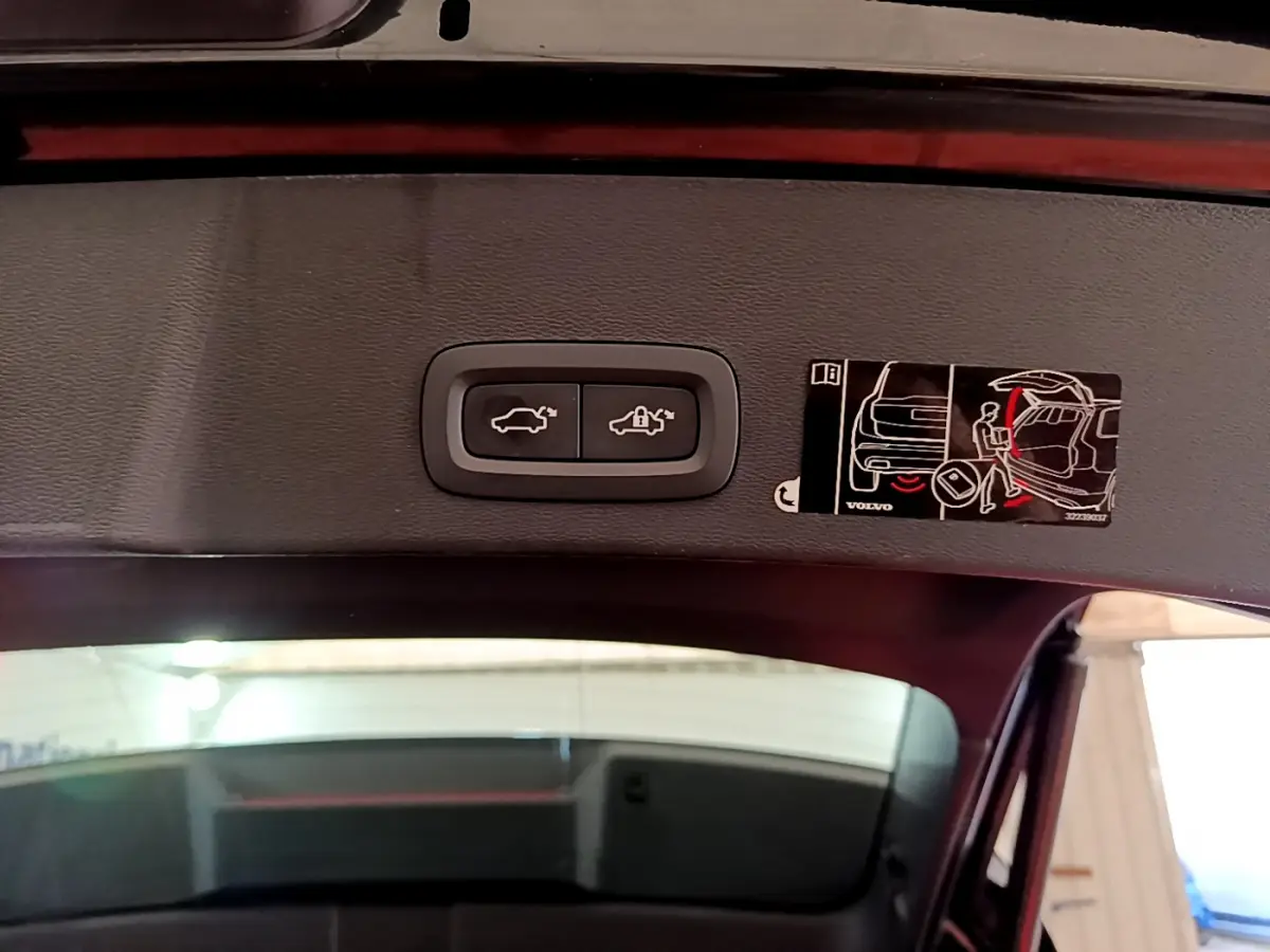 Gros plan sur les boutons d'ouverture et de verrouillage du coffre électrique du Volvo XC40 noir, vue depuis l'intérieur du coffre.