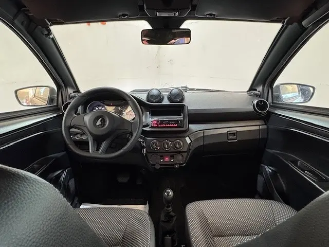 Vue intérieure avant de l'AIXAM AMBITION 0.5 CITY PACK 2026 gris foncé, tableau de bord simple avec volant et rétroviseur caméra côté conducteur.