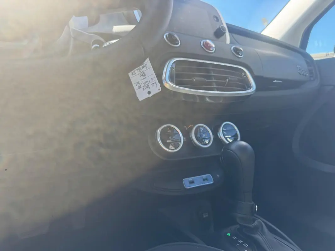 Intérieur du Fiat 500X bleu MY23, vue sur la console centrale avec levier de vitesse automatique et commandes de climatisation.