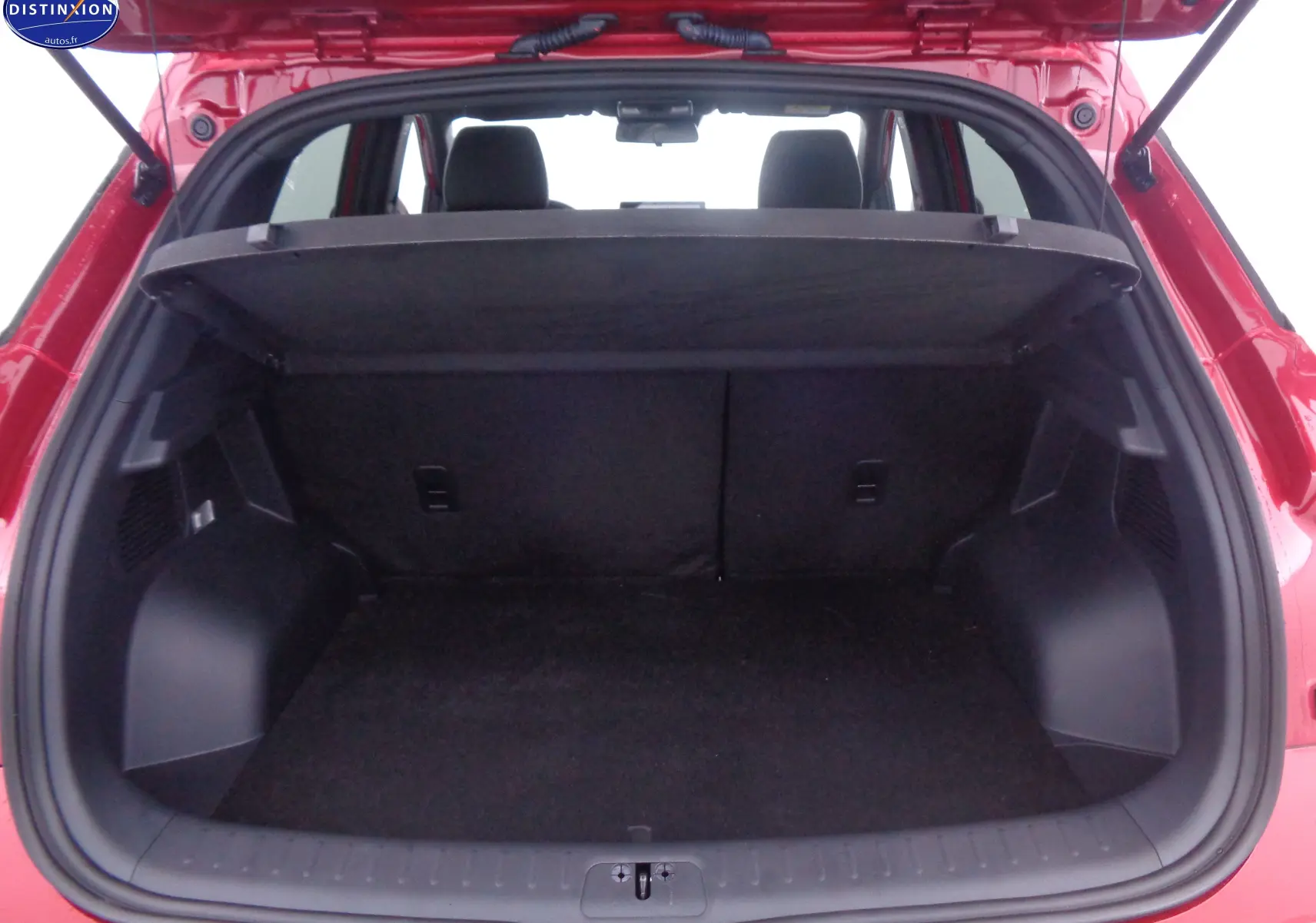 Coffre ouvert vu de l'arrière d'un SERES 3 rouge solaire métallisé, montrant l'espace de chargement et la plage arrière.