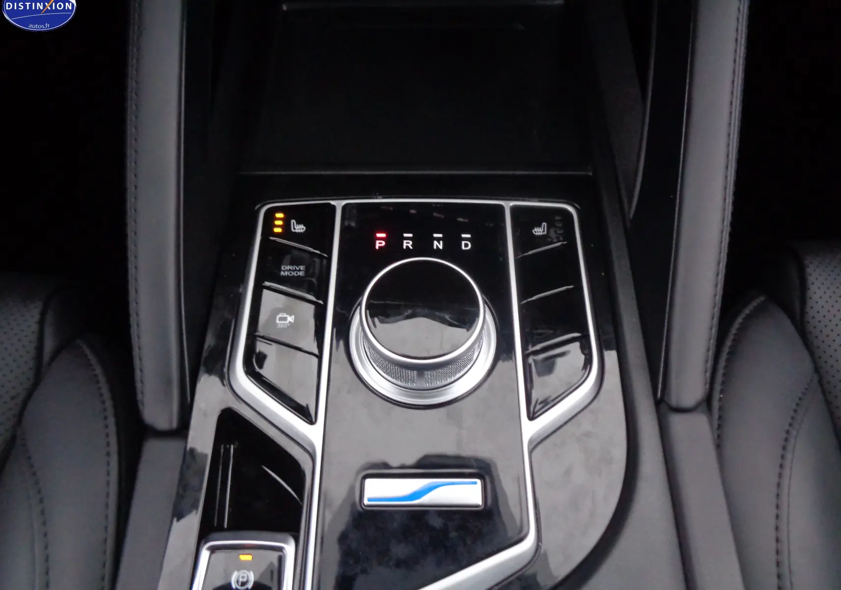 Gros plan sur la console centrale noire brillante du SERES 3 électrique avec molette de boîte auto et commandes chauffantes.