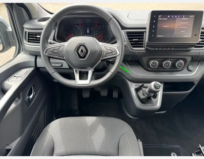 Vue intérieure avant du Renault Trafic Fourgon gris Highland, volant multifonctions, tableau de bord avec écran tactile et boîte manuelle.