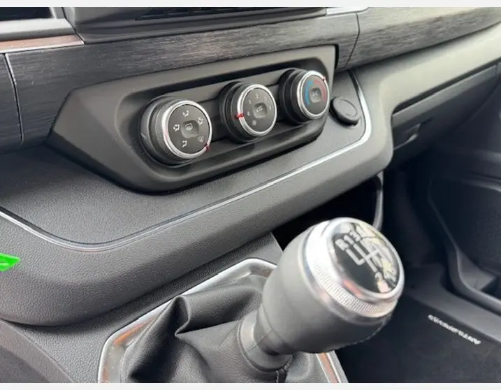 Gros plan sur la console centrale et levier de vitesse manuel du Renault Trafic Fourgon gris Highland 2025.