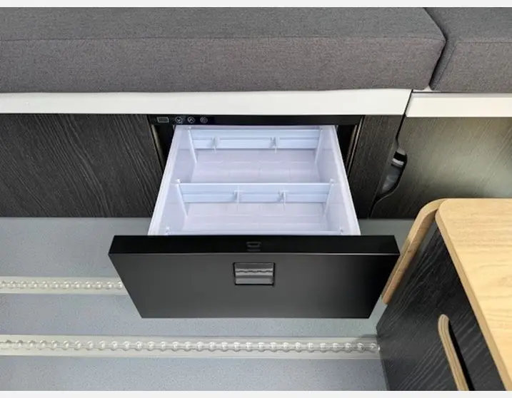 Tiroir de rangement noir ouvert dans l'aménagement intérieur du Renault Trafic Fourgon Antilope Gris Highland.