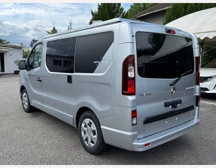 Vue 3/4 arrière droite du Renault Trafic Fourgon gris Highland avec vitres latérales surteintées et hayon arrière vitré.