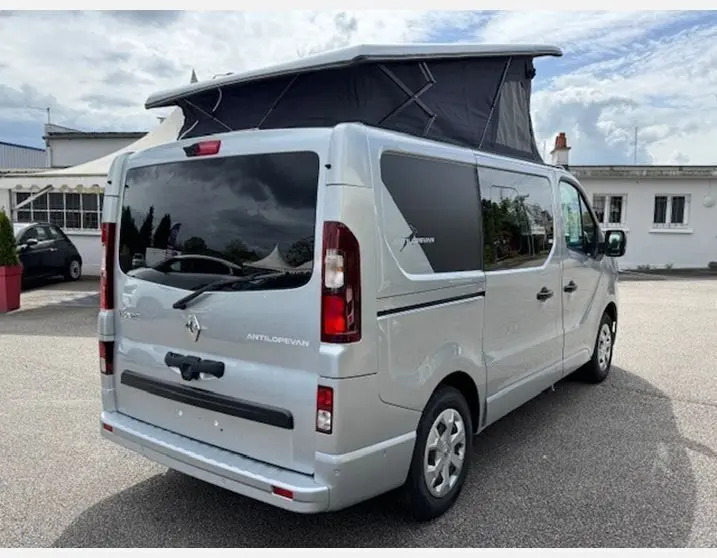 Vue 3/4 arrière droite du Renault Trafic Fourgon Antilope Van Flex Plus gris Highland avec toit relevé et vitres surteintées.