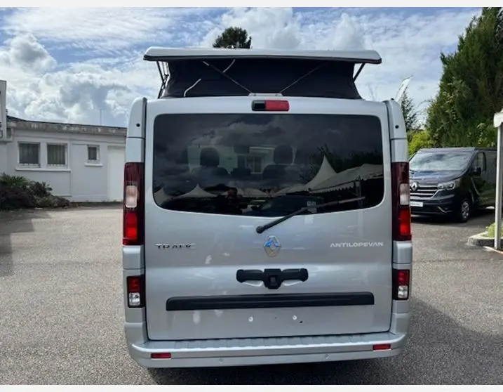 Vue arrière d'un Renault Trafic Fourgon Antilope Van Flex Plus gris Highland avec toit relevable déployé.