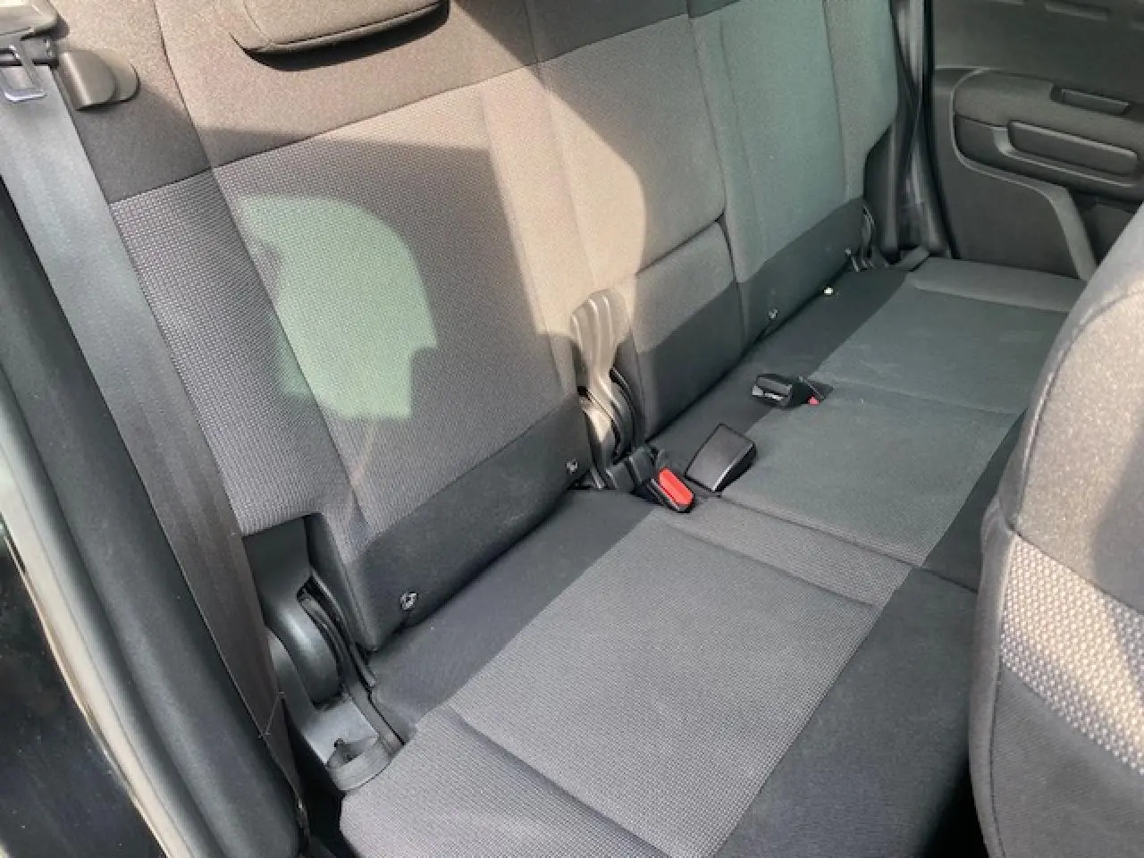 Vue intérieure du siège arrière droit du Citroën C3 Aircross noir, tissu gris avec ceintures et fixations Isofix visibles.