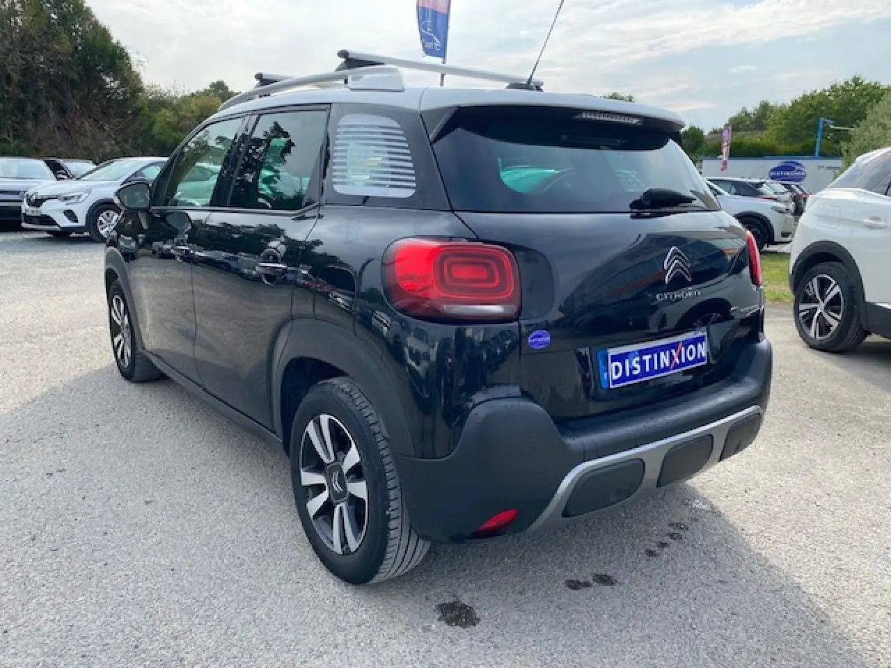 Vue 3/4 arrière droite d'un Citroën C3 Aircross noir avec toit blanc et feux arrière LED distinctifs.
