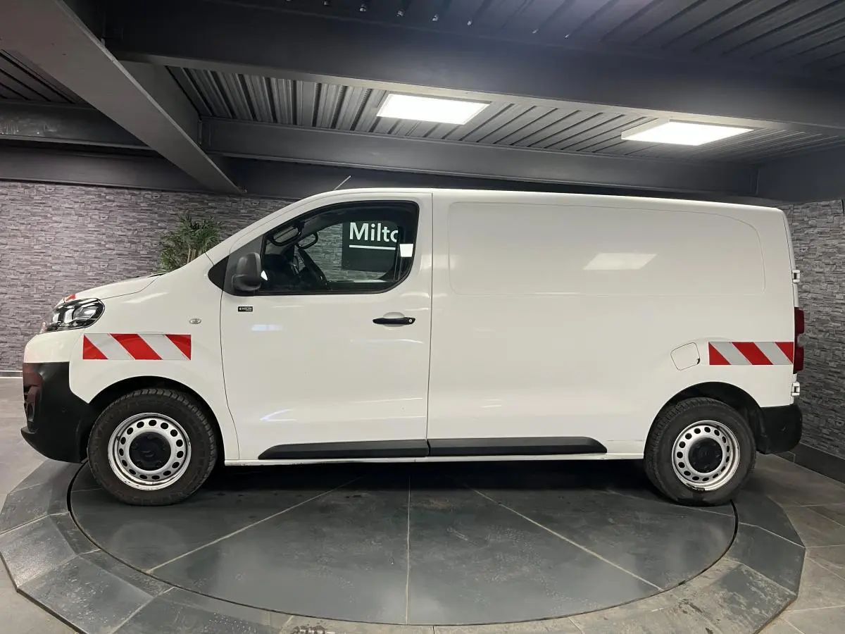 Profil droit du Citroën Jumpy blanc avec bandes réfléchissantes rouges et blanches sur ailes avant et arrière.