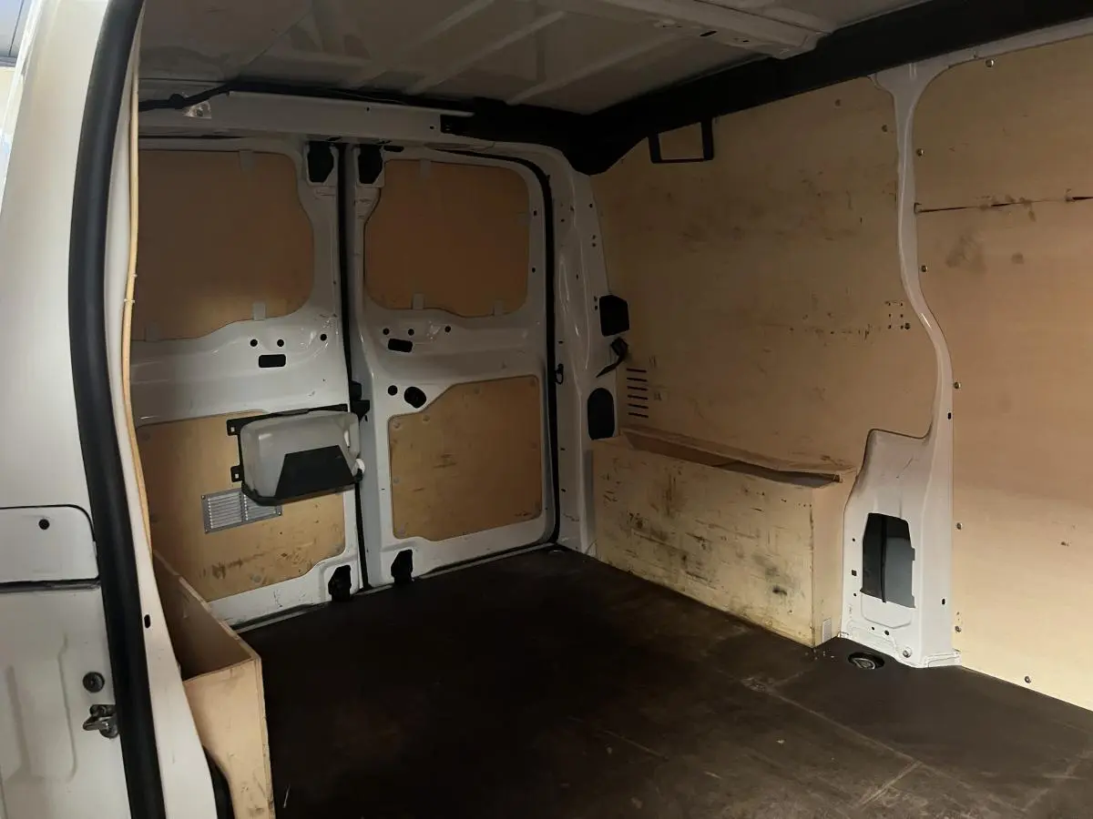 Intérieur du coffre du Citroën Jumpy blanc, vue arrière avec habillage bois et espace de chargement vide.