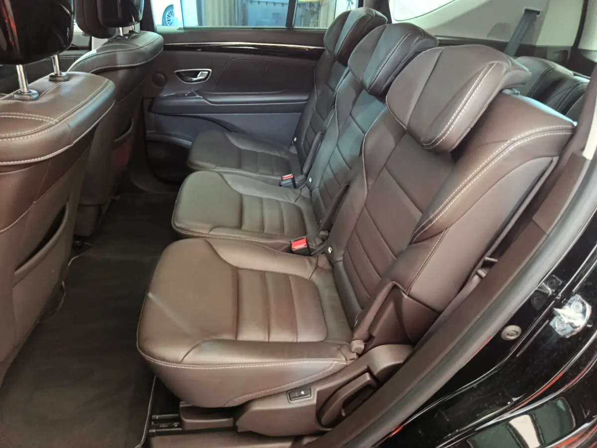 Vue côté droit sur la banquette arrière en cuir marron du Renault Espace noir, avec détails de couture apparents.