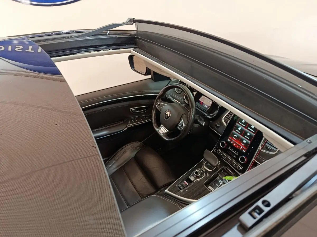 Vue intérieure côté conducteur du Renault Espace noir 2018, volant cuir, écran tactile central et toit ouvrant panoramique visible.