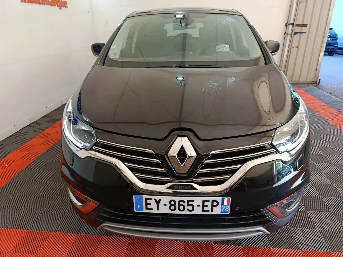 Vue frontale rapprochée du Renault Espace Initiale Paris noir, avec calandre chromée et phares LED allumés.