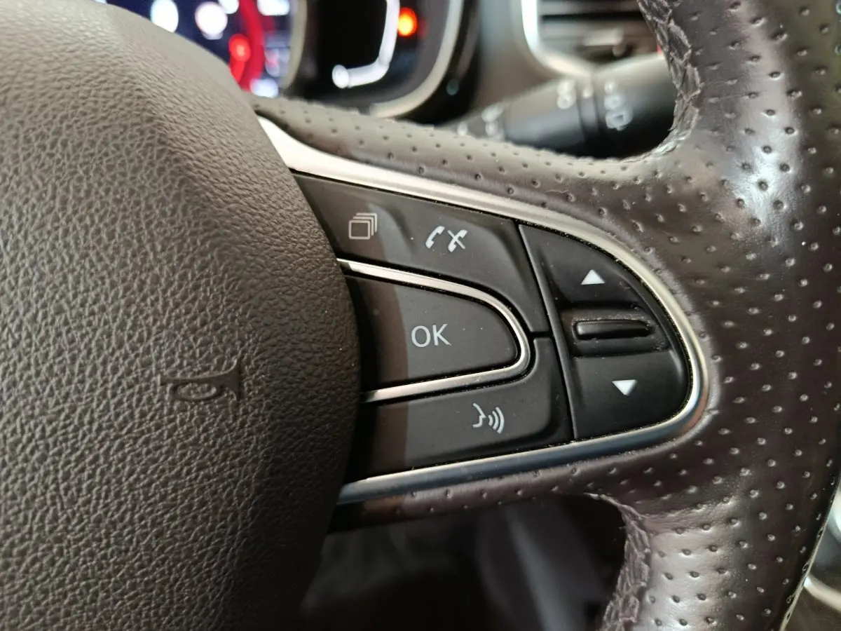 Gros plan sur les commandes multifonctions à droite du volant en cuir perforé du Renault Espace Initiale Paris noir de 2018.