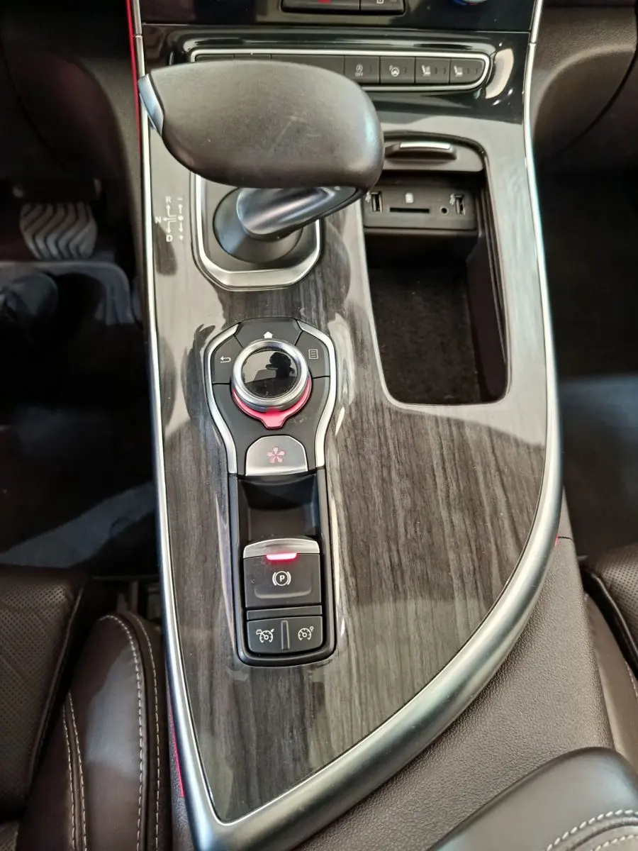 Vue plongeante sur la console centrale en bois sombre avec levier de vitesse et commandes du Renault Espace noir Initiale Paris 2018.