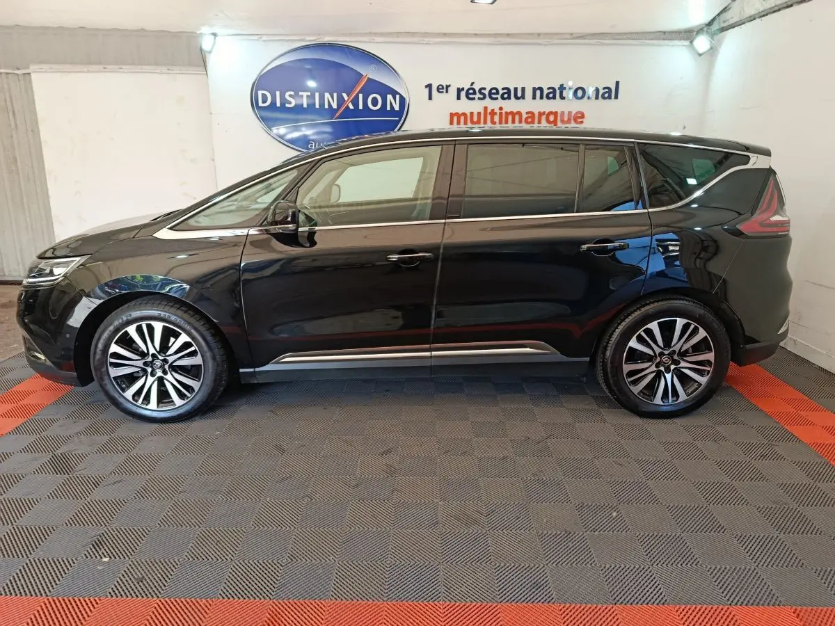 Profil côté gauche d'un Renault Espace noir 2018 avec jantes alliage et vitres teintées en intérieur showroom.