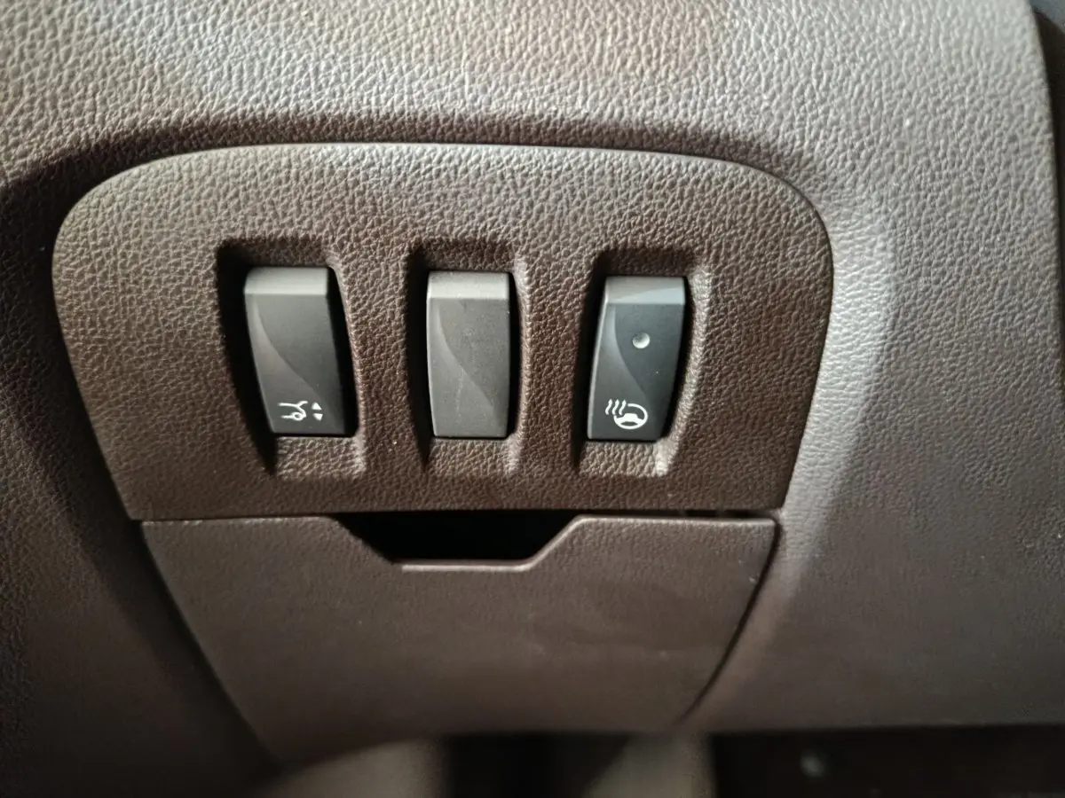 Gros plan sur les commandes noires en plastique intégrées au tableau de bord marron du Renault Espace Initiale Paris 2018.