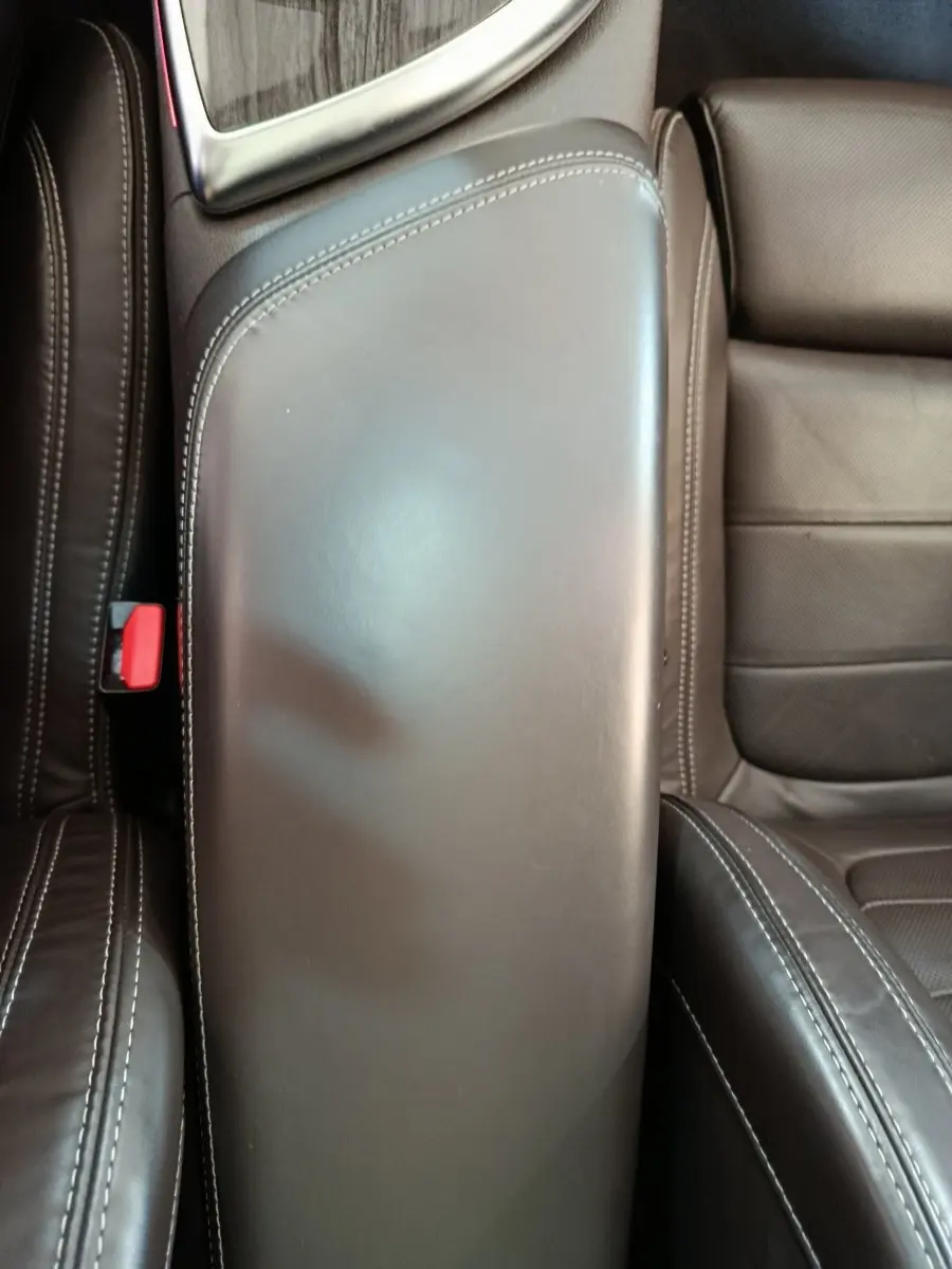 Accoudoir central en cuir noir avec surpiqûres blanches, entre les sièges avant du Renault Espace noir 2018.