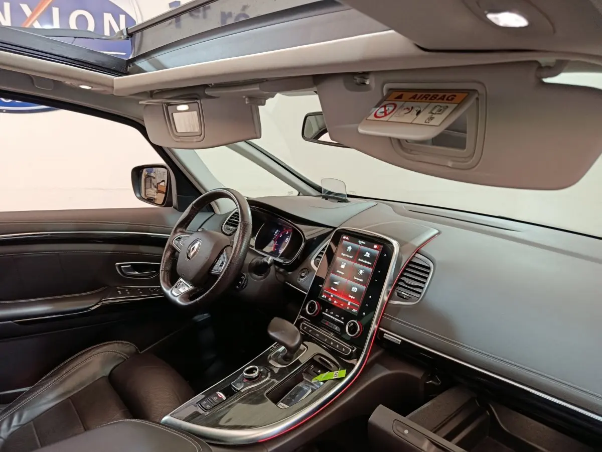 Vue intérieure côté conducteur du Renault Espace noir 2018, tableau de bord moderne avec écran tactile vertical et toit ouvrant panoramique.