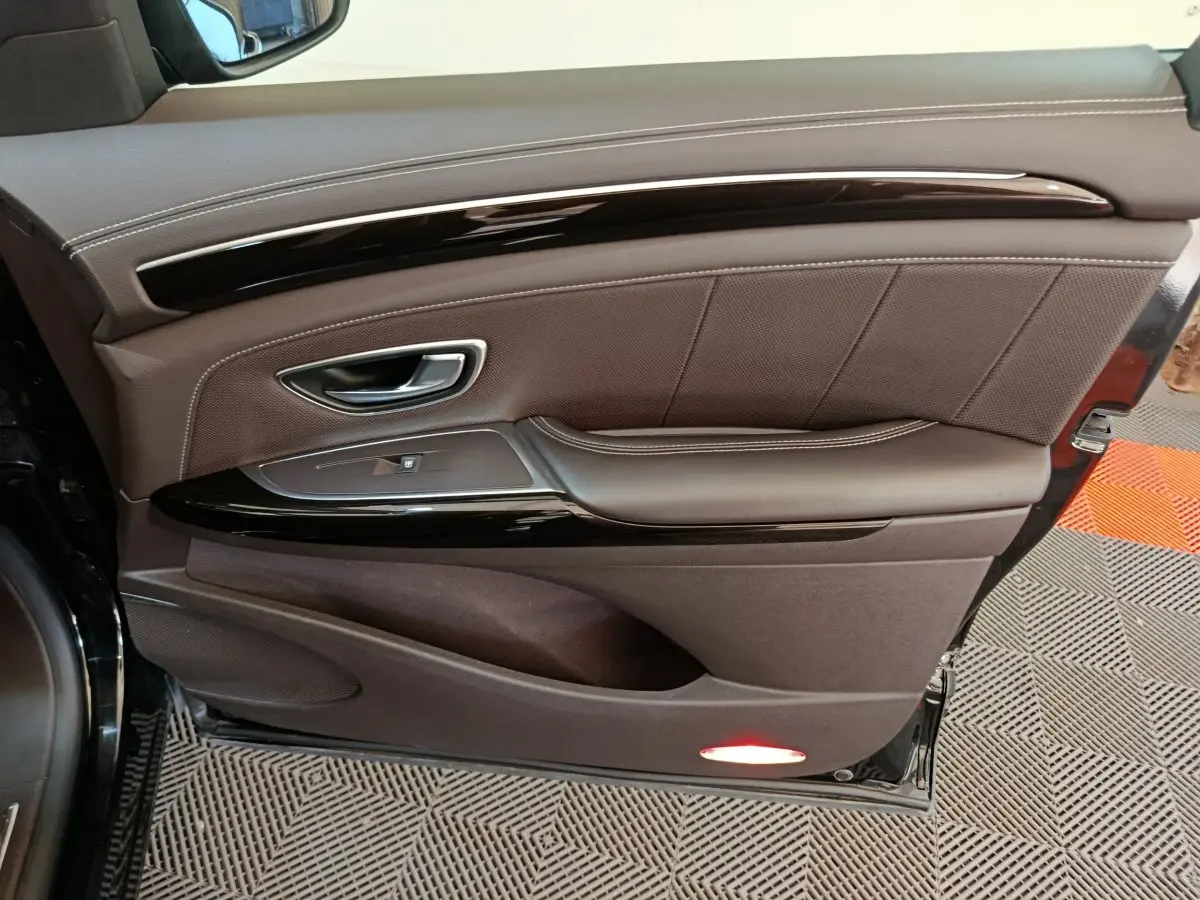 Vue rapprochée de la porte côté gauche noire du Renault Espace Initiale Paris, avec garniture cuir marron et insert laqué noir.
