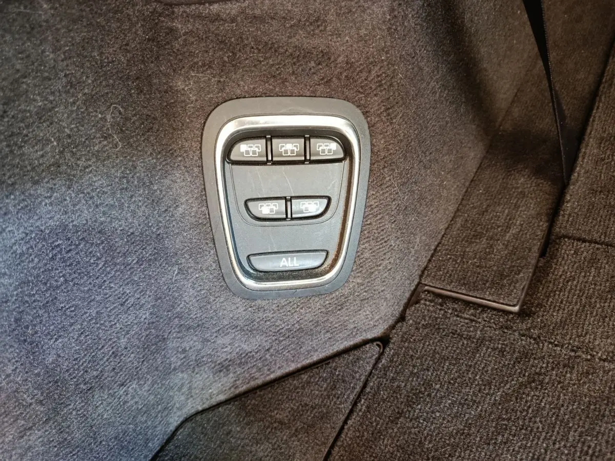 Boutons de commande des sièges rabattables dans le coffre du Renault Espace noir, vue en gros plan.