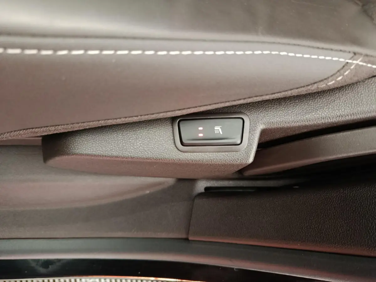 Gros plan sur le bouton de siège chauffant activé sous la sellerie cuir noire du Renault Espace Initiale Paris 2018