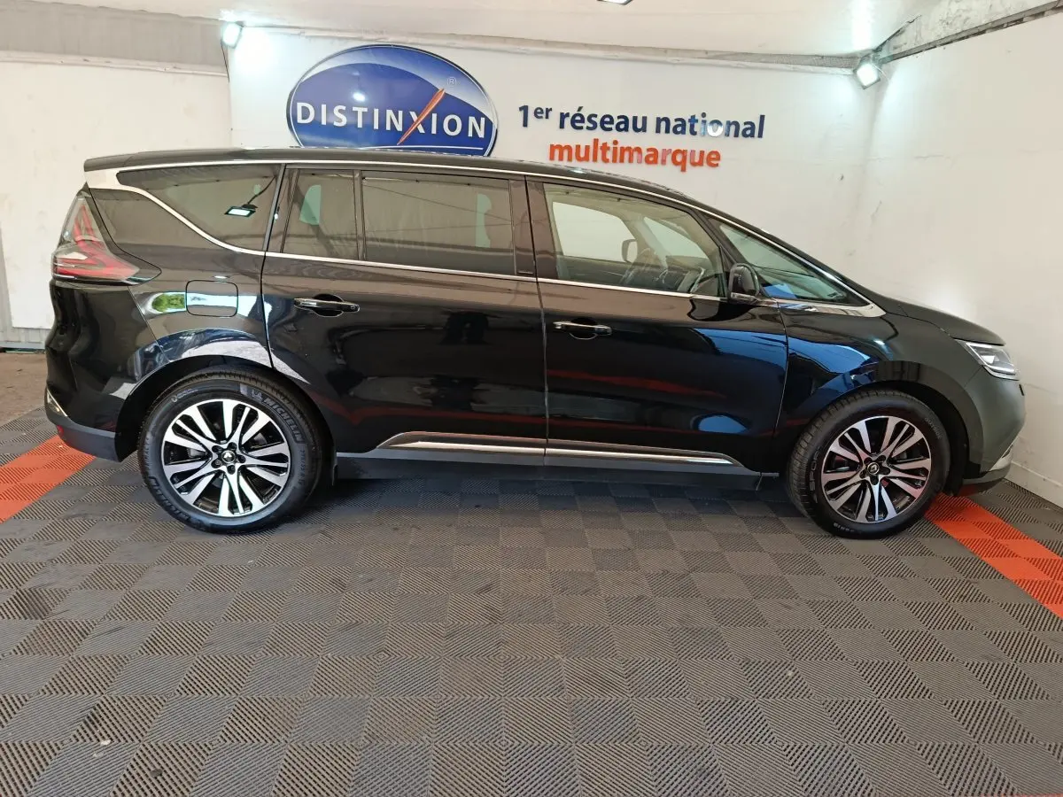 Profil côté gauche d'un Renault Espace noir 2018 garé en intérieur avec jantes alliage bicolores et vitres teintées.