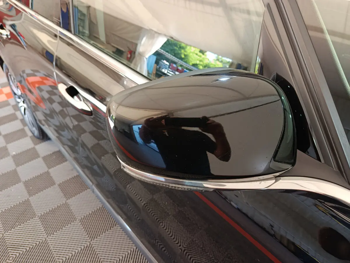 Rétroviseur côté droit noir brillant de la Renault Espace Initiale Paris 2018, avec poignée de porte et reflet visible.