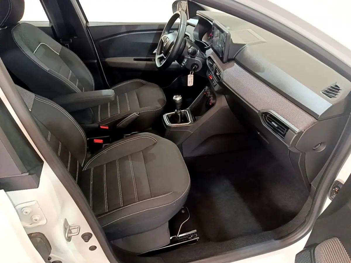 Intérieur avant droit de la Dacia Sandero Confort TCe 90 2022 avec sièges noirs et tableau de bord moderne.