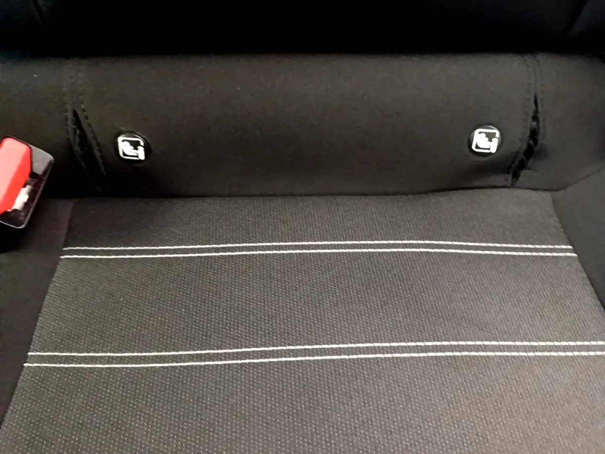 Gros plan sur la banquette arrière noire de la Dacia Sandero Confort TCe 90 avec logos Isofix visibles.