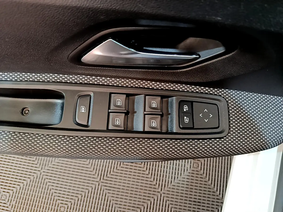 Détail des commandes des vitres et rétroviseurs sur la porte côté conducteur d'une Dacia Sandero blanche 2022 Confort TCe 90.