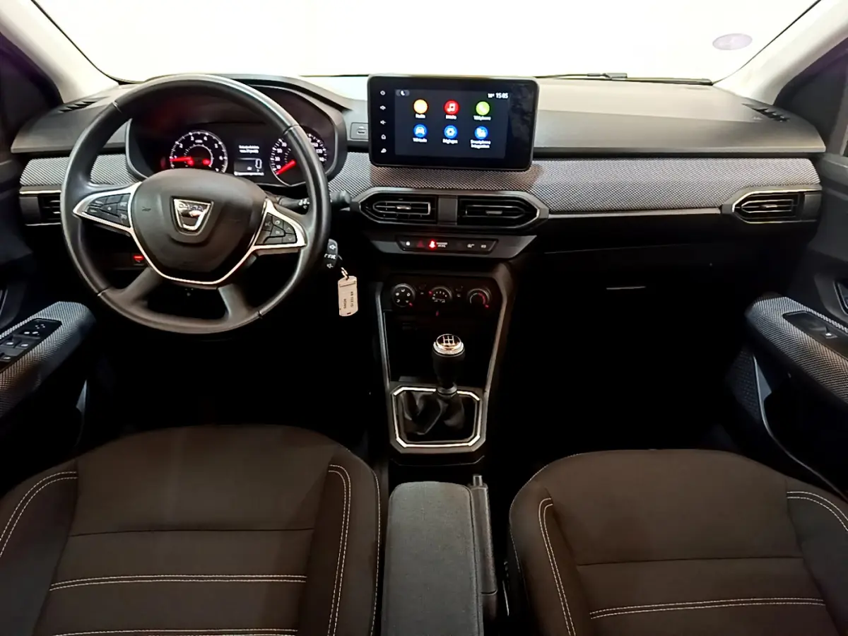 Vue intérieure avant de la Dacia Sandero Confort TCe 90 2022, tableau de bord avec écran tactile et volant multifonctions.