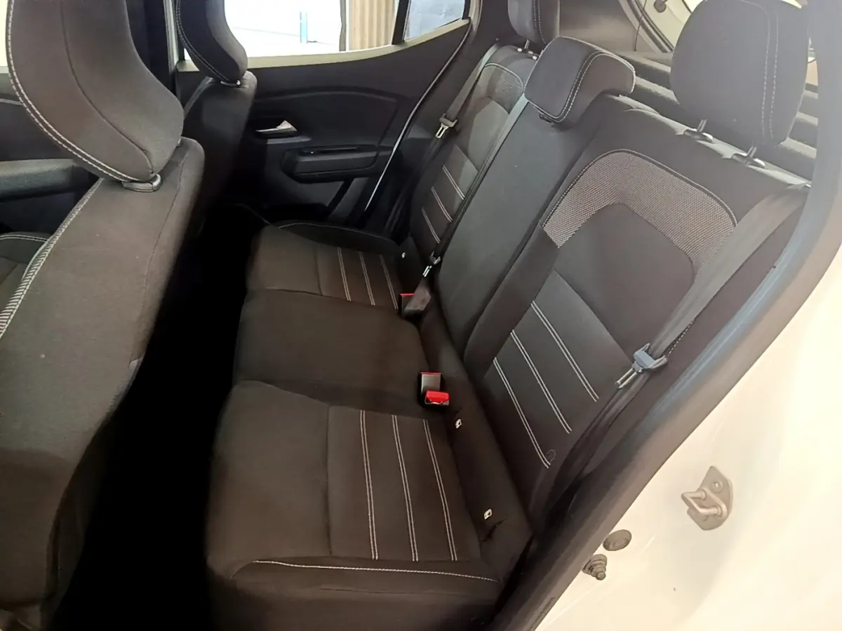 Vue intérieure côté droit des sièges arrière noirs avec surpiqûres blanches d'une Dacia Sandero blanche 2022 Confort TCe 90.