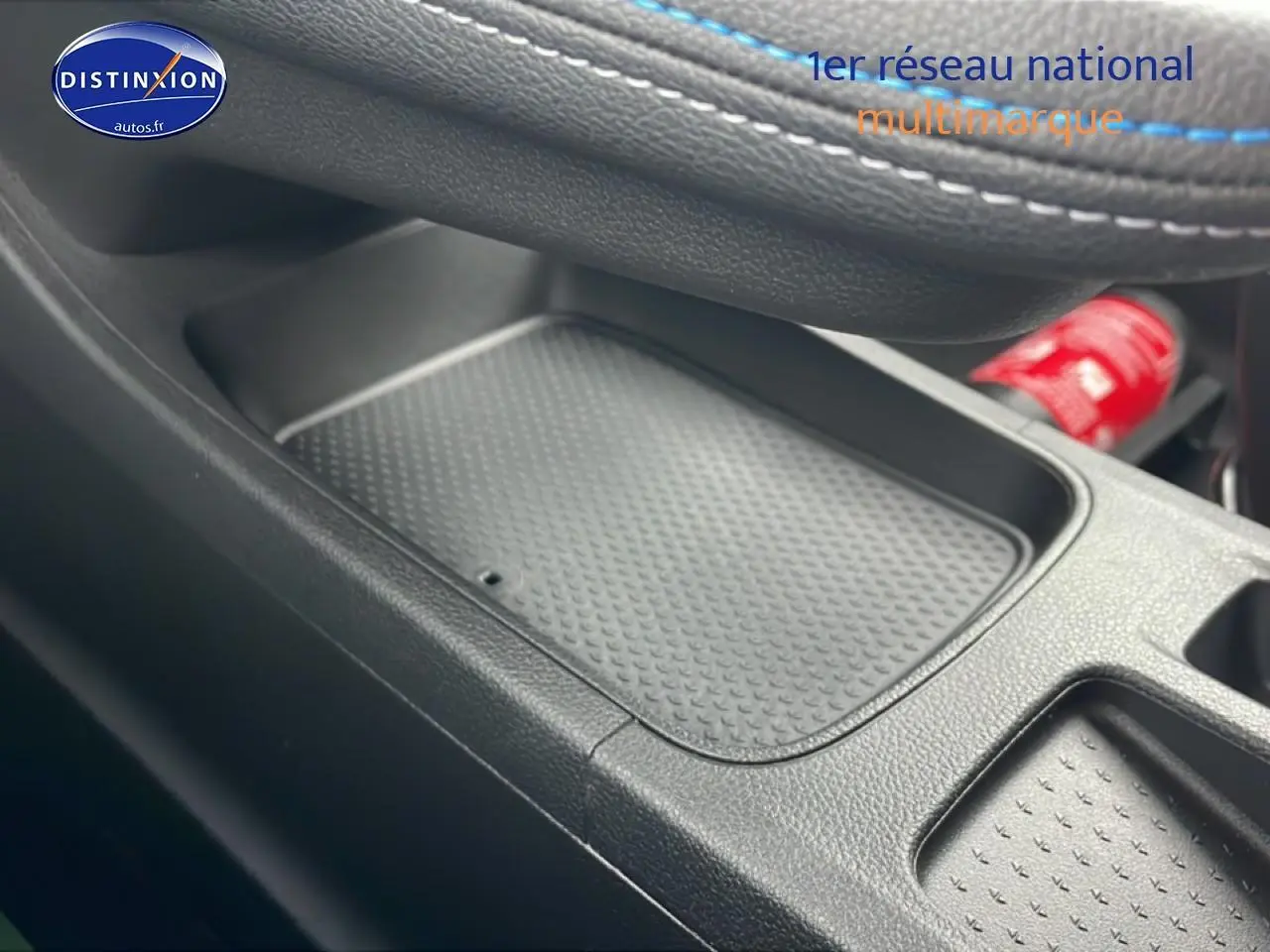 Gros plan sur le rangement central noir avec surpiqûres bleues du Renault Captur 1.8 e-tech hybride 2025 esprit Alpine.