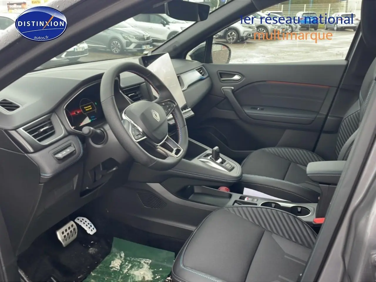 Vue intérieure côté conducteur du Renault Captur gris cassiopée, volant cuir multifonction et écran tactile vertical.