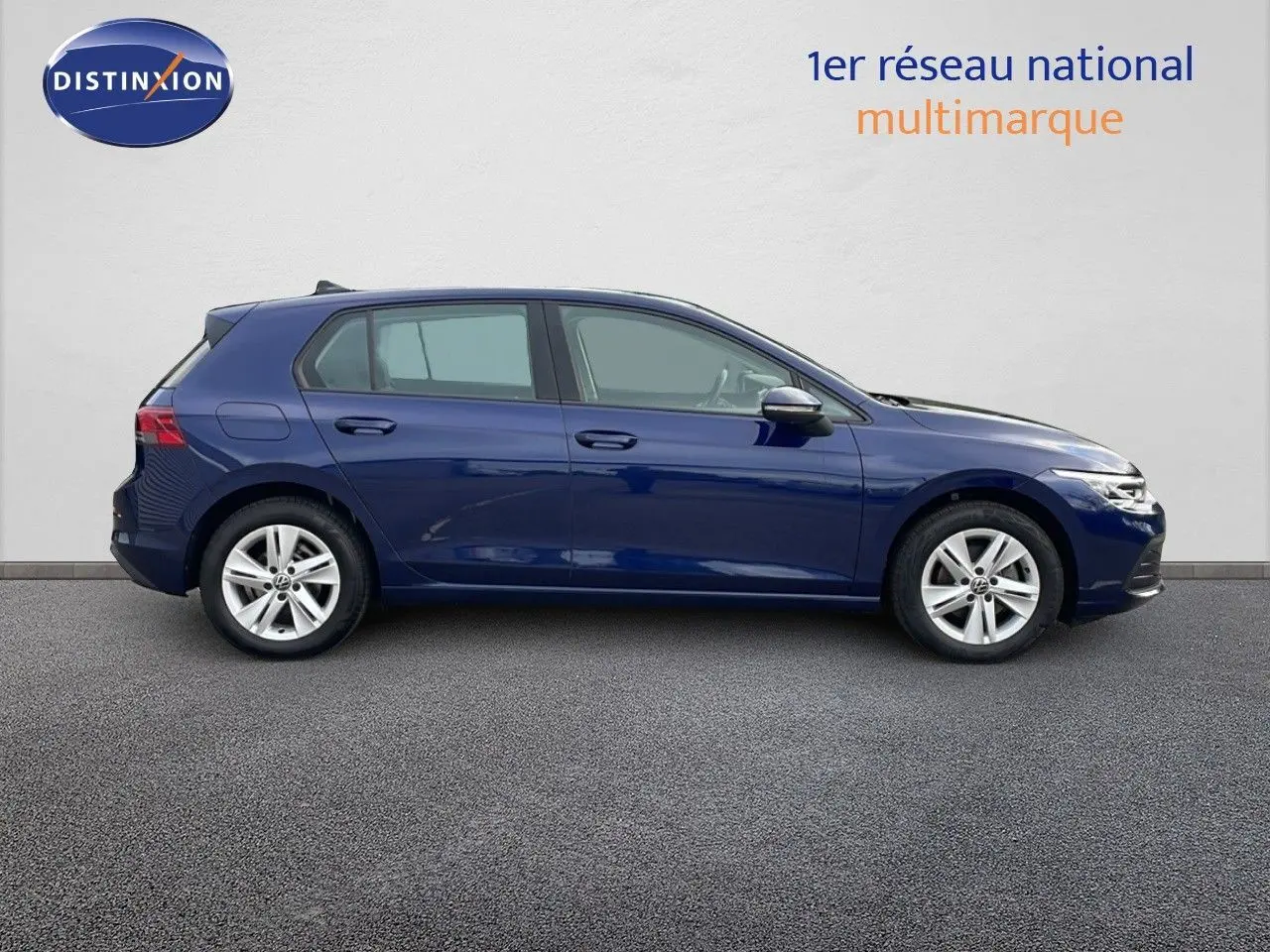 Profil côté gauche d'une Volkswagen Golf VIII bleu lapiz metal, 5 portes, sur fond neutre, en lumière naturelle.