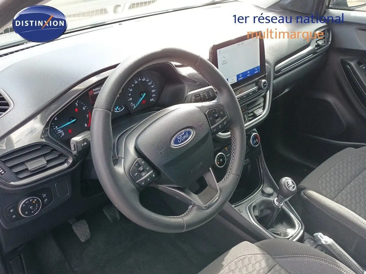 Vue intérieure côté conducteur du Ford Puma 2023 gris foncé, volant multifonction et levier de vitesse manuel visibles.