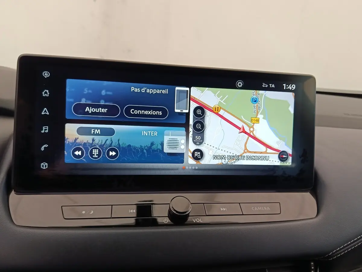 Écran tactile central du tableau de bord du Nissan Qashqai Tekna 2023 affichant navigation et radio FM.