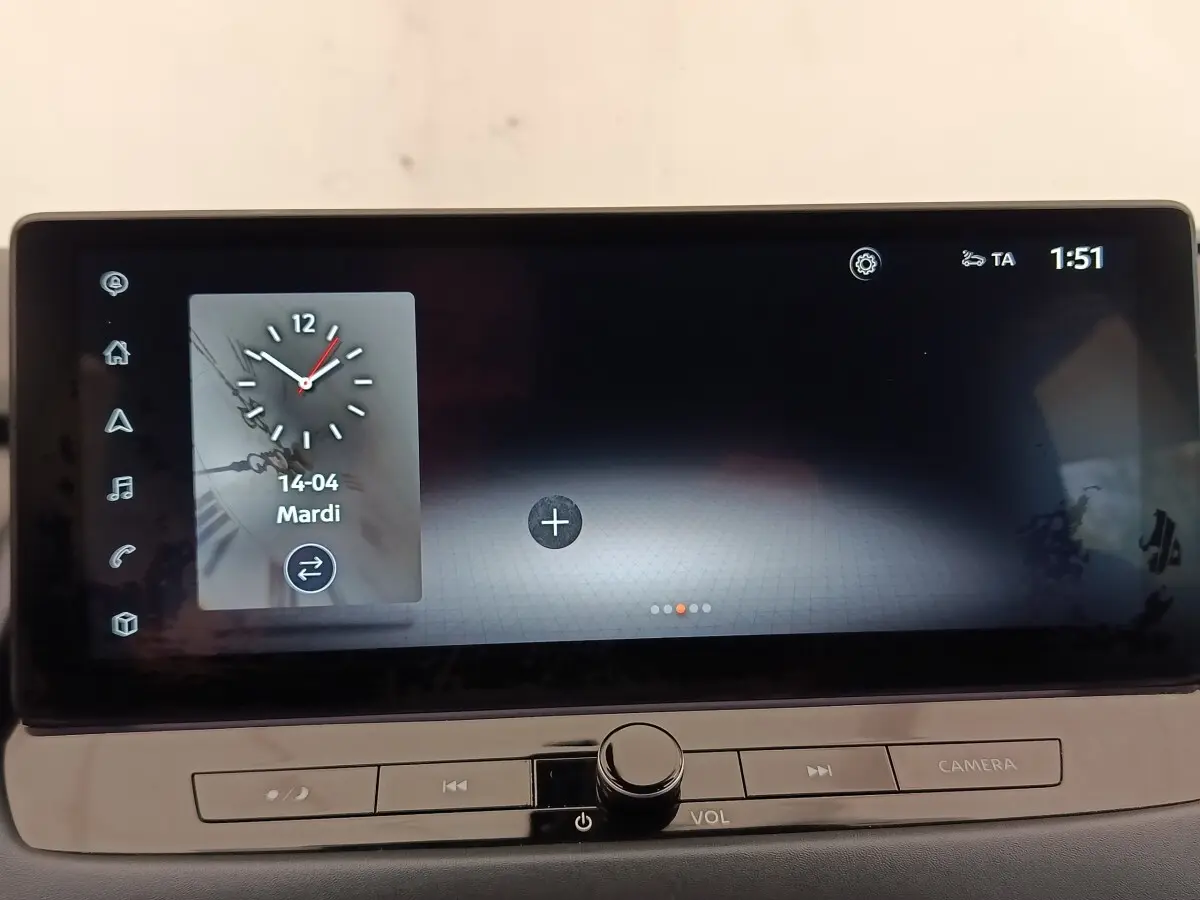 Écran tactile central du Nissan Qashqai 2023 affichant une horloge digitale, boutons de contrôle en dessous.