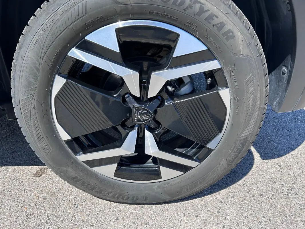 Gros plan sur la jante alliage 17 pouces noire et argentée du Peugeot 2008 Hybrid 136 e-DCS6 Allure noir.