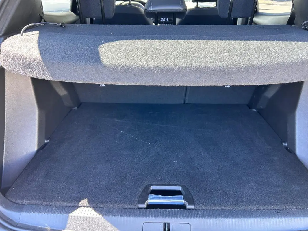Vue intérieure du coffre noir du Peugeot 2008 Hybrid 136 e-DCS6 Allure, avec cache-bagages déployé.