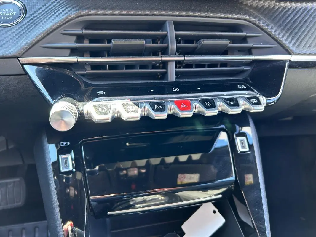 Vue rapprochée du tableau de bord noir du Peugeot 2008 Hybrid 136 e-DCS6 Allure avec commandes tactiles et bouton start/stop.