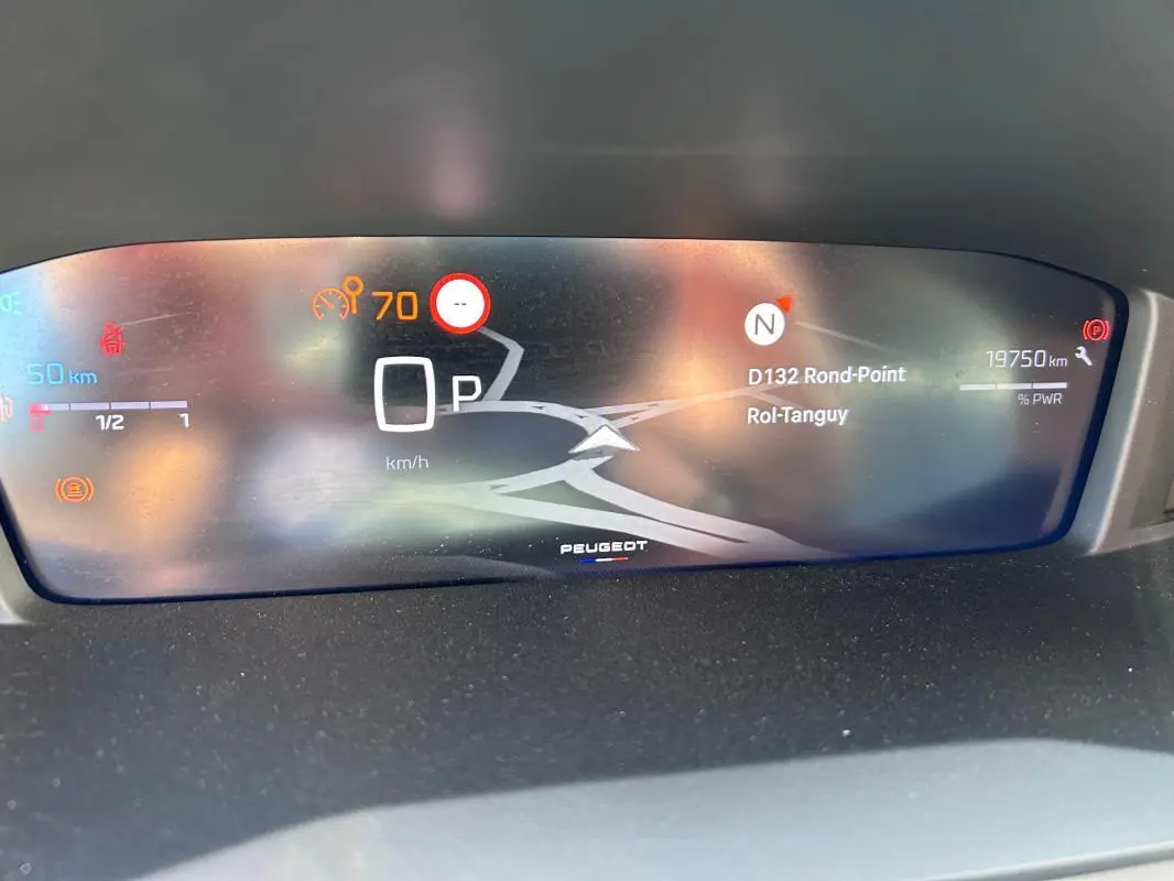 Affichage numérique du cockpit du Peugeot 2008 Hybrid 136, avec navigation et indicateurs de vitesse et distance.