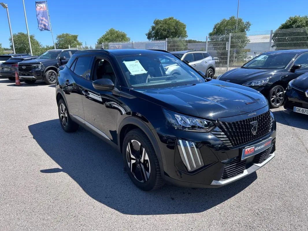 Peugeot 2008 Hybrid noir en 3/4 avant droit, avec barres de toit et jantes alliage 17 pouces visibles.