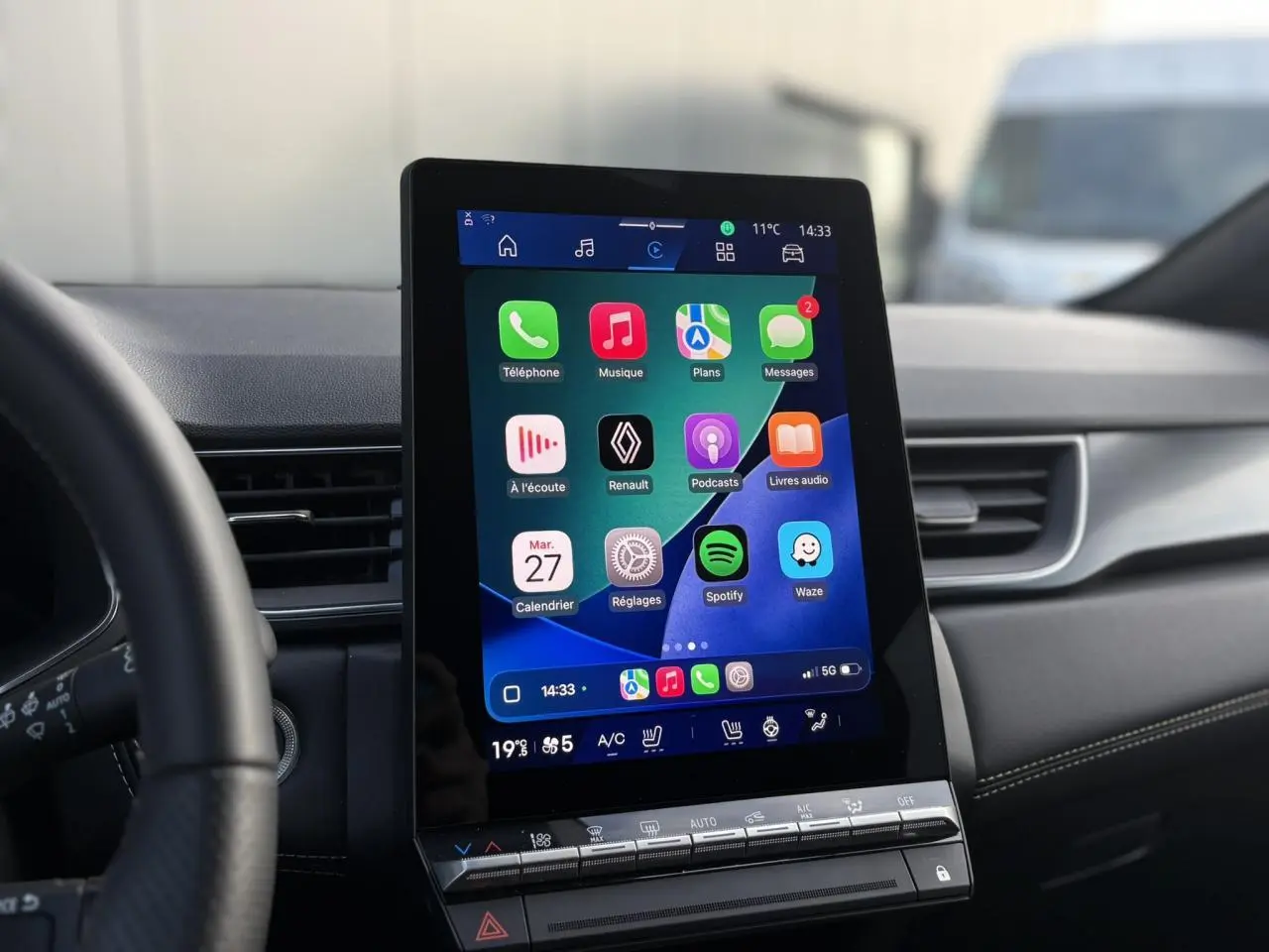 Vue intérieure centrée sur l'écran tactile vertical du tableau de bord du Renault Symbioz 2025, avec interface connectée colorée.