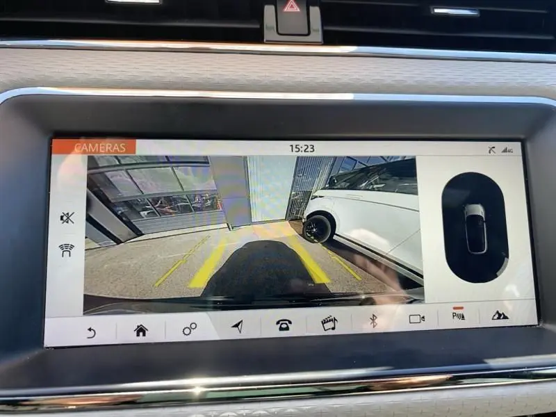 Vue caméra de recul du Range Rover Evoque gris foncé métal, montrant le côté droit et l'arrière du véhicule en stationnement.